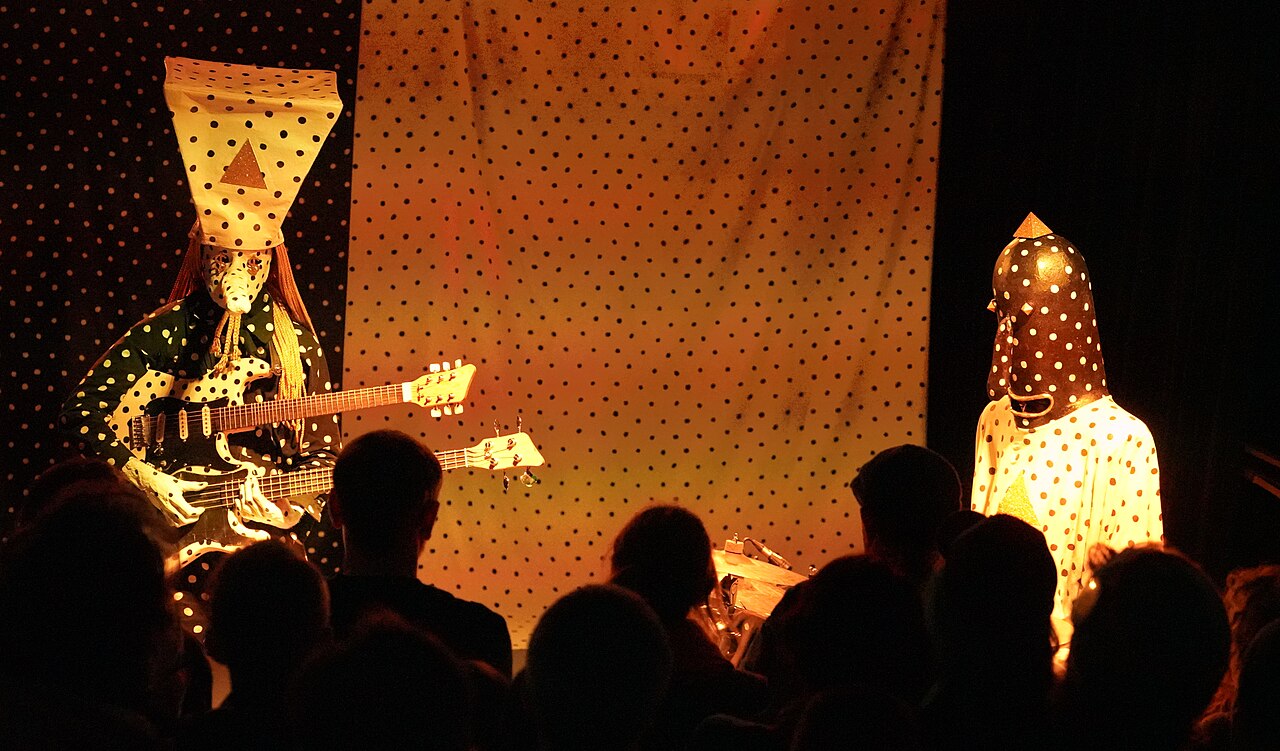 The band Angine de Poitrine onstage with audience members visible in the foreground